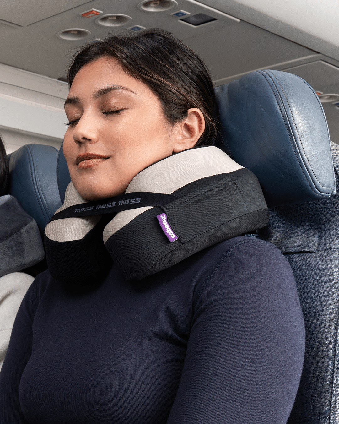 Woman sleeping comfortably with neck pillow on an airplane