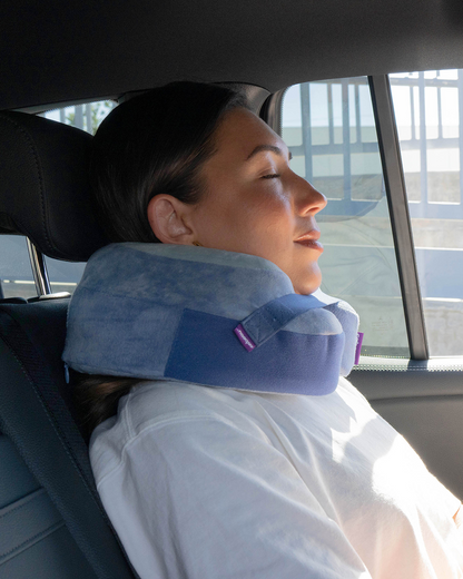 Woman resting comfortably with a Cabeau Evolution Earth Deluxe neck pillow in a car