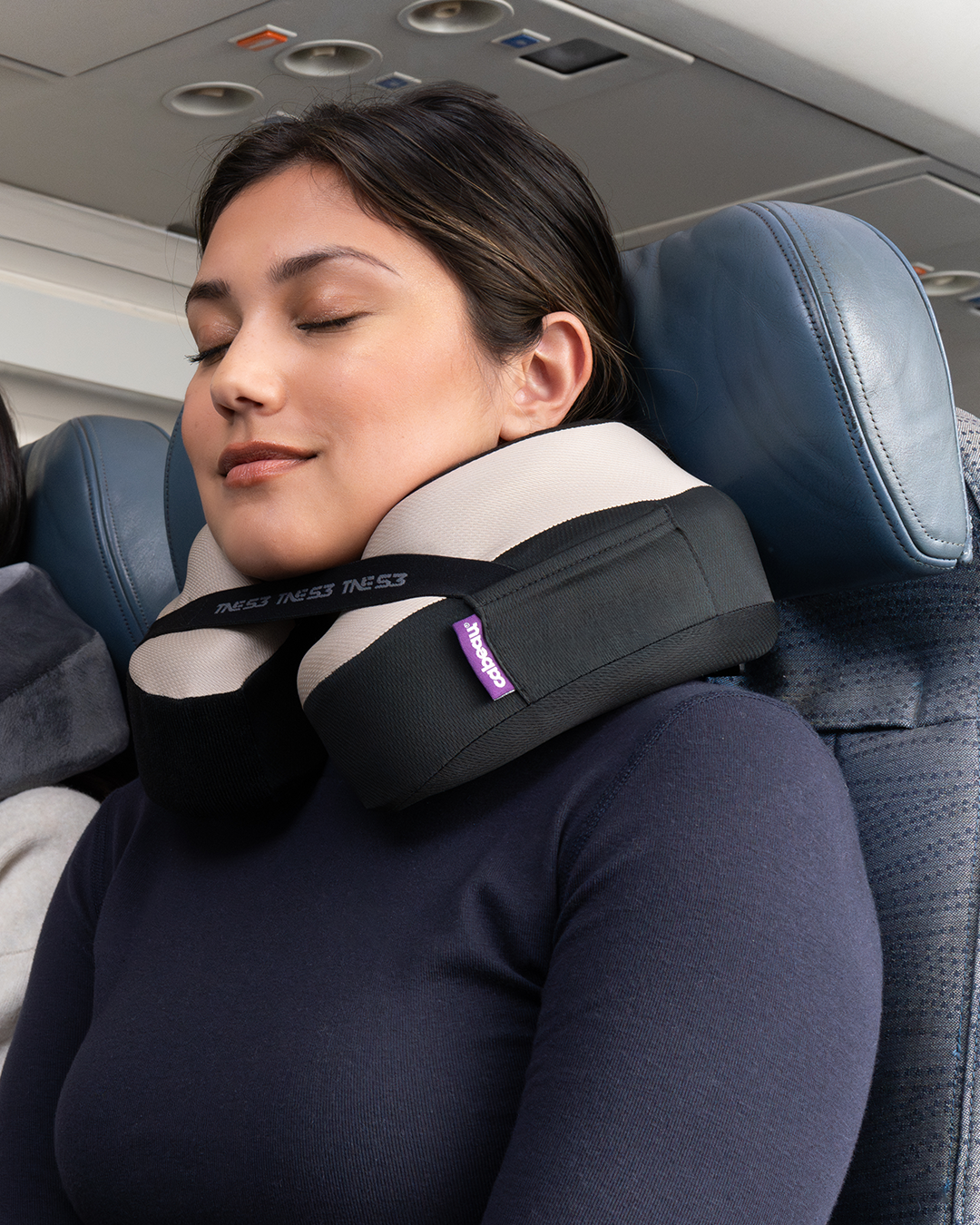 Woman sleeping comfortably with neck pillow on an airplane