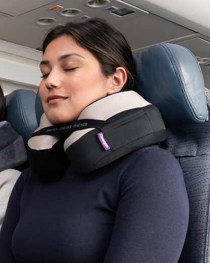 Woman sleeping comfortably with neck pillow on an airplane